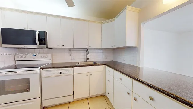 a kitchen with white cabinets stainless steel appliances and sink