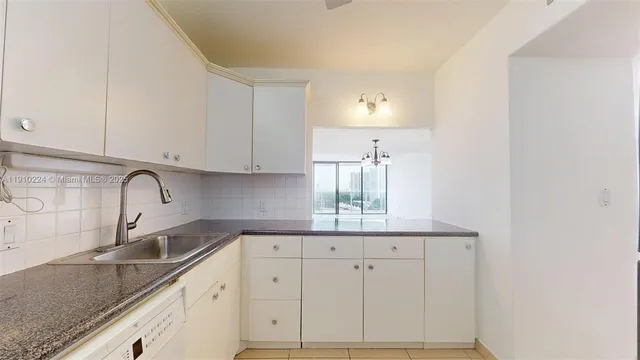 a kitchen with granite countertop white cabinets and a sink