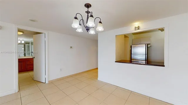 a view of a hallway with wooden floor and chandelier