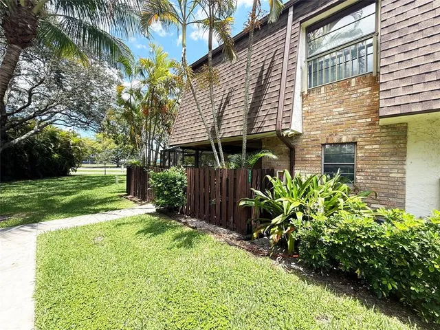 a view of a house with a yard and potted plants