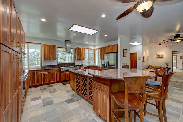 a large kitchen with a large island in the center and stainless steel appliances