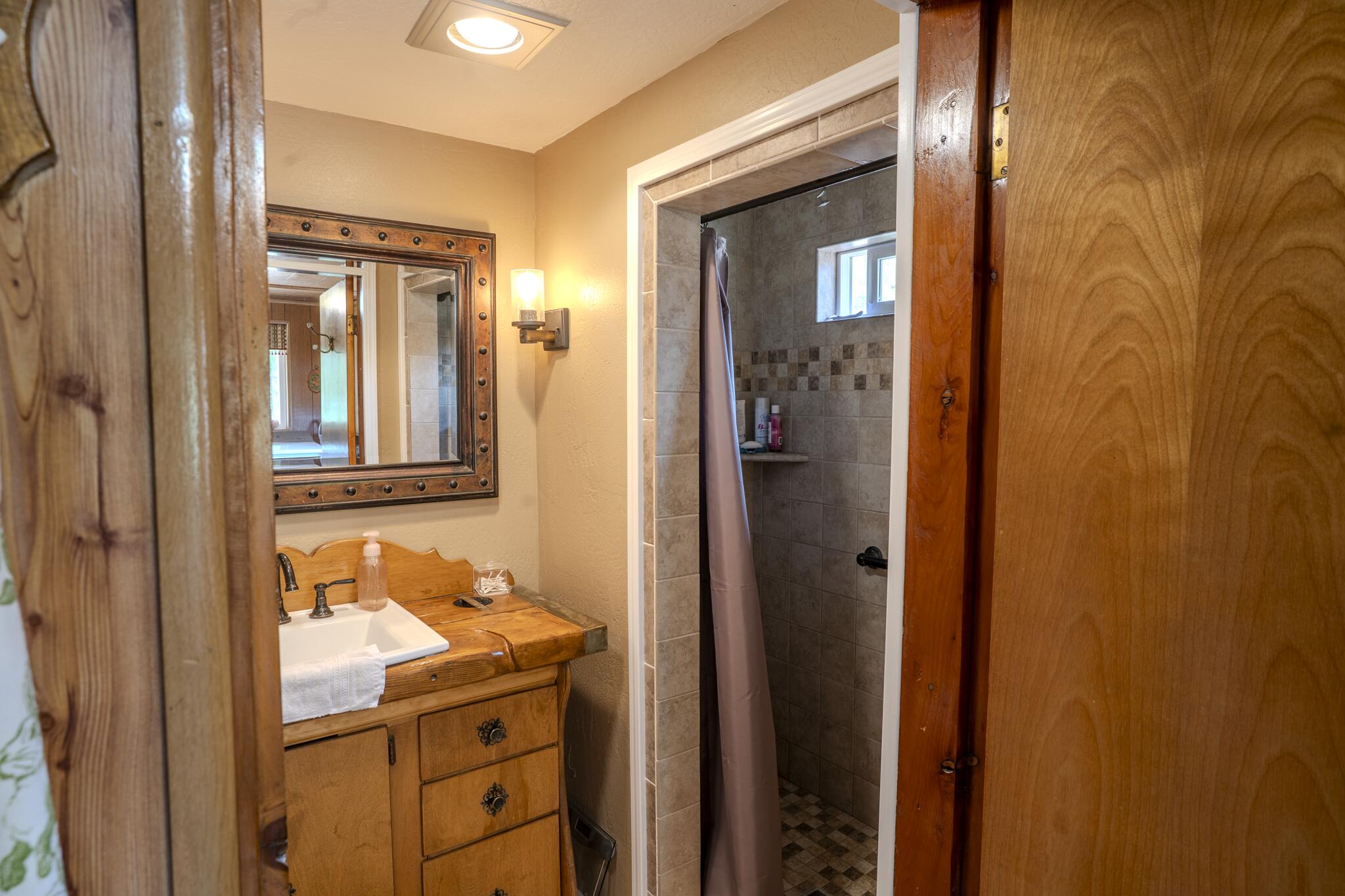 1969 Colestin Road Ashland, OR 97520 - Photo 47 of 72 a bathroom with a granite countertop sink and a mirror