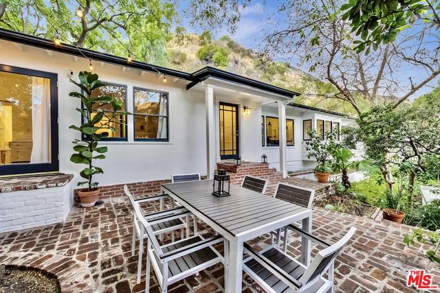 a view of a patio with table and chairs and potted plants