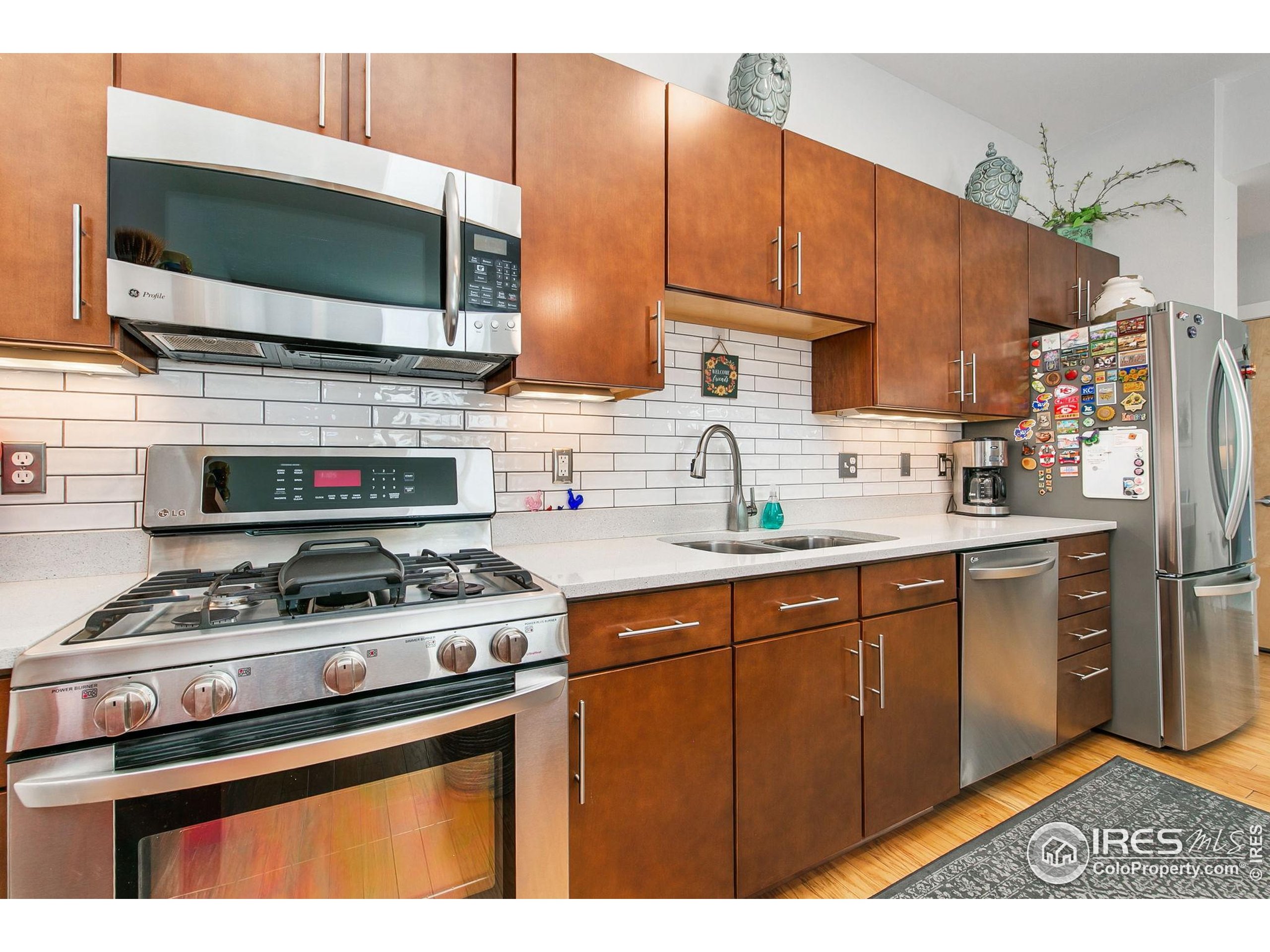 204 Maple Street, Unit 207 Fort Collins, CO 80521 - Photo 11 of 21 a kitchen with stainless steel appliances a stove a sink and a microwave
