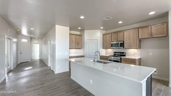 a kitchen with stainless steel appliances granite countertop a sink stove and refrigerator