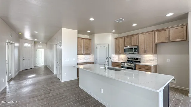 a kitchen with stainless steel appliances granite countertop a sink stove and refrigerator