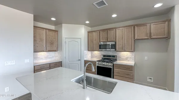a kitchen with stainless steel appliances granite countertop a stove a refrigerator and a microwave