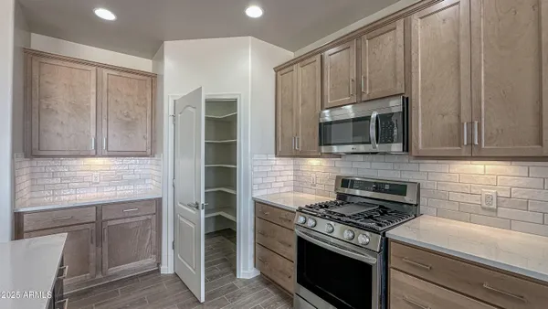 a kitchen with granite countertop a stove and a microwave