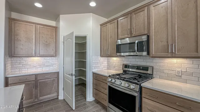 a kitchen with granite countertop a stove and a microwave