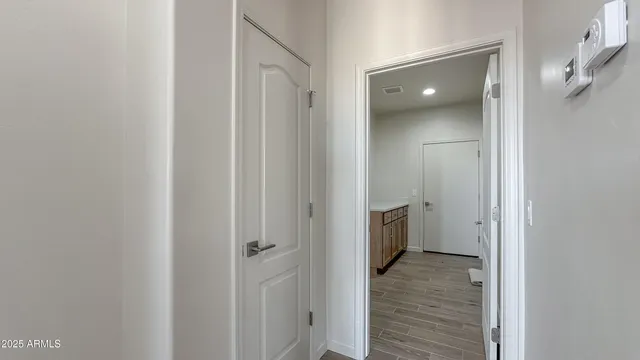 a view of a hallway with wooden floor and closet