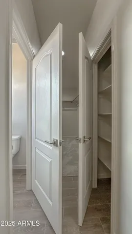 a view of a walk in closet and a bathroom