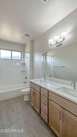 a bathroom with a tub sink and mirror