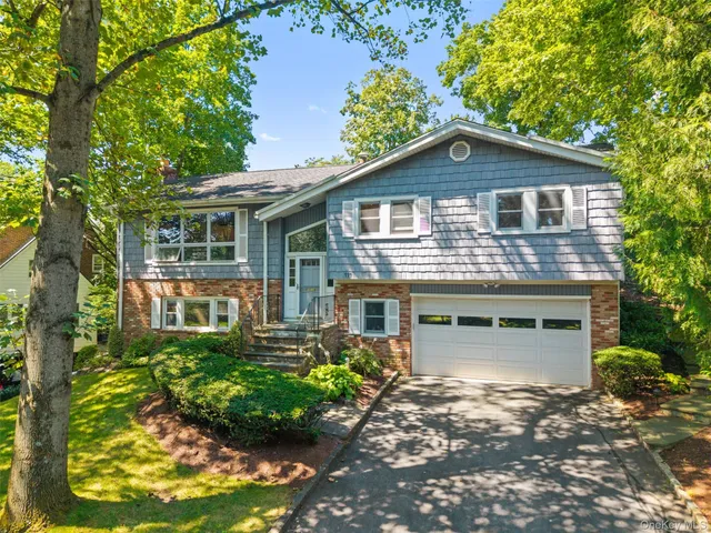 a front view of a house with a yard and potted plants