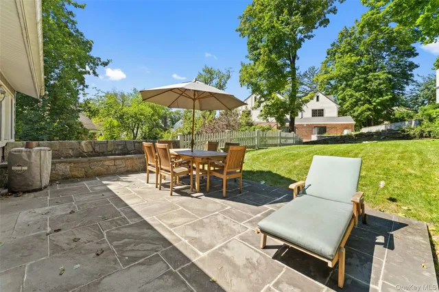 a view of a patio with table and chairs under an umbrella
