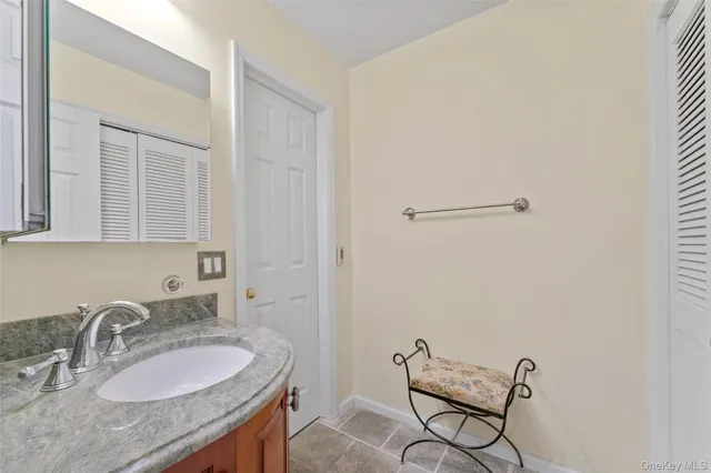 a bathroom with a granite countertop sink and a mirror