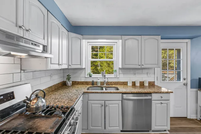 a kitchen with a sink stove top oven and cabinets