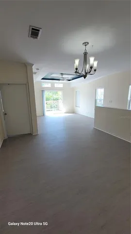 an empty room with windows and ceiling fan view