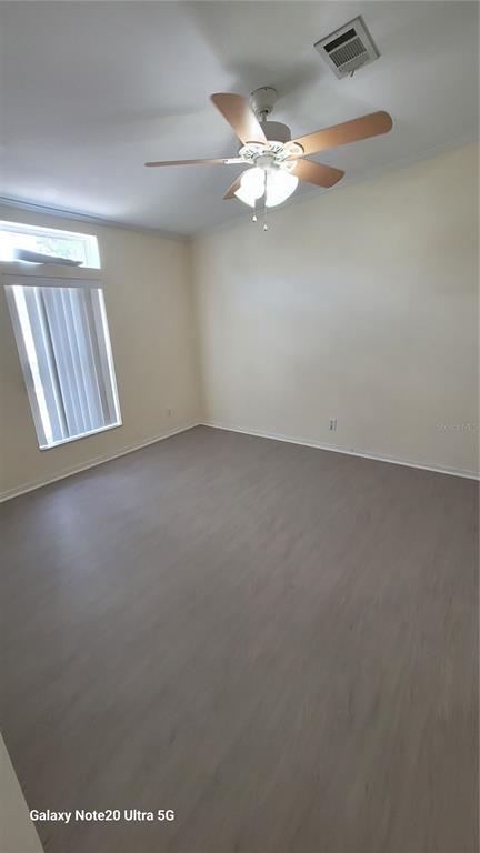 4936 Marina Palms Drive Port Richey, FL 34668 - Photo 9 of 19 an empty room with a chandelier fan and wooden floor