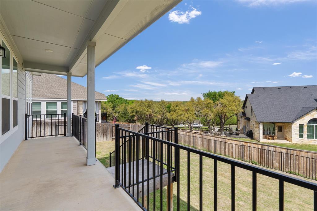236 Prato Place Georgetown, TX 78628 - Photo 39 of 40 A spacious covered deck extends along the home, overlooking a fenced yard and natural greenery.