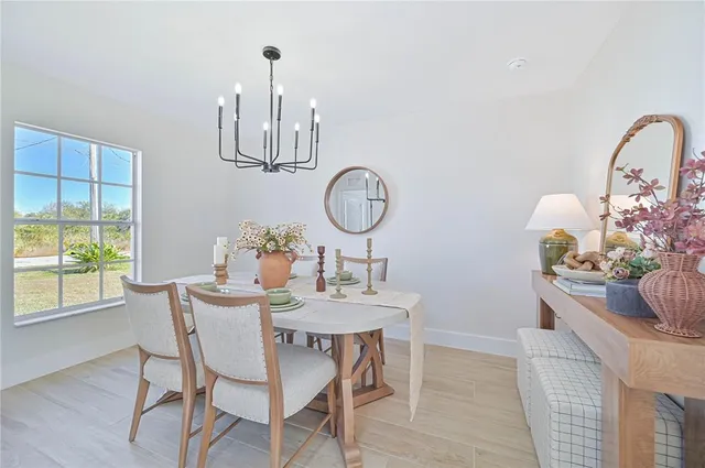 a view of a dining room with furniture a chandelier and wooden floor