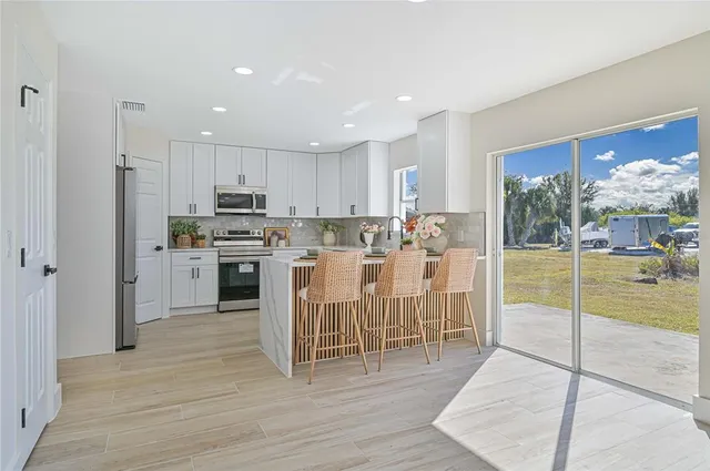 a kitchen with stainless steel appliances granite countertop a stove top oven a sink and a refrigerator