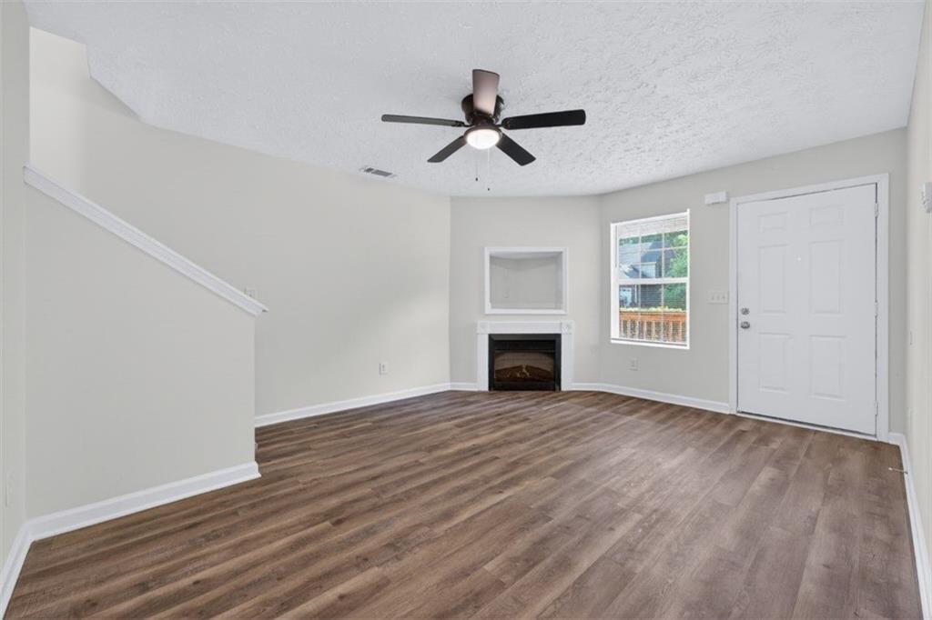 1424 Steam Engine Way Northeast Conyers, GA 30013 - Photo 11 of 32 an empty room with wooden floor fireplace and windows