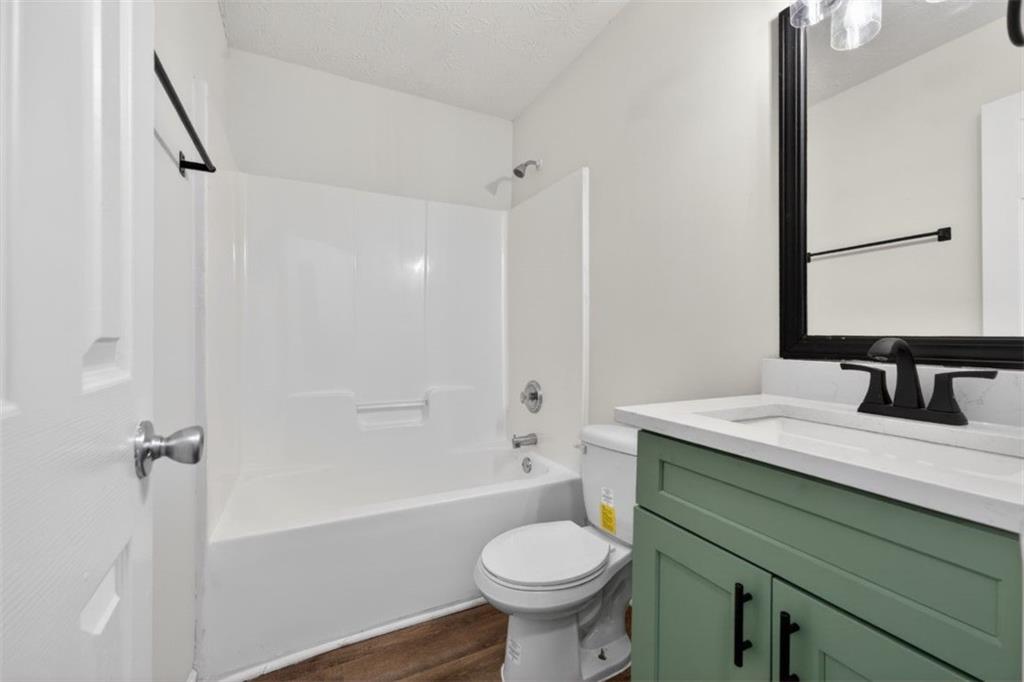 1424 Steam Engine Way Northeast Conyers, GA 30013 - Photo 14 of 32 a bathroom with a sink toilet a mirror and shower