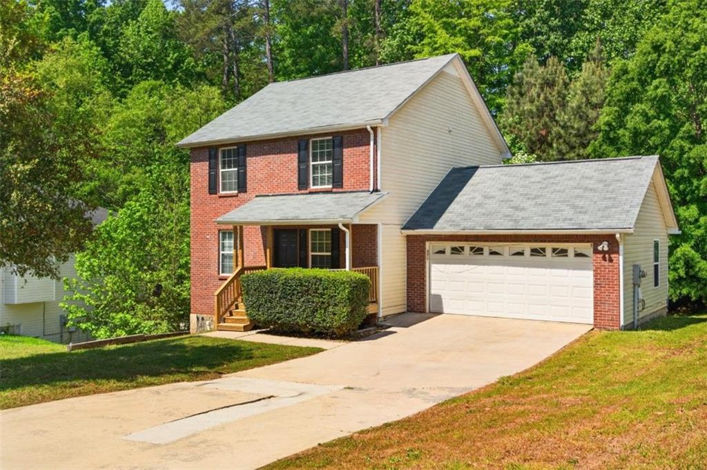 1424 Steam Engine Way Northeast Conyers, GA 30013 - Photo 6 of 32 a front view of a house with a garden and garage