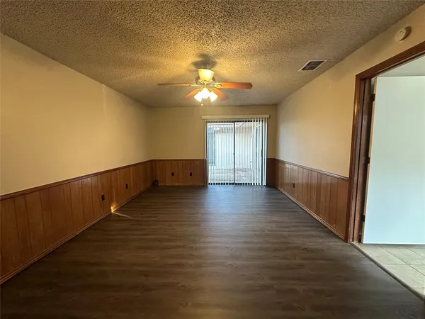 a view of room with wooden floor and ceiling fan
