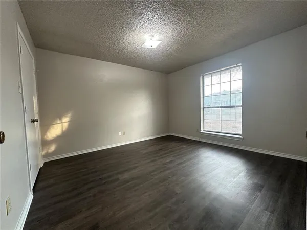 an empty room with wooden floor & closet