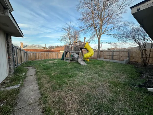 a view of a house with backyard and a tree