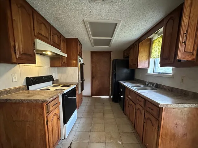a kitchen with stainless steel appliances granite countertop a stove a sink dishwasher and a refrigerator