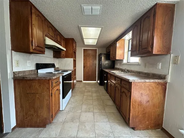 a kitchen with stainless steel appliances granite countertop a stove a refrigerator and a sink