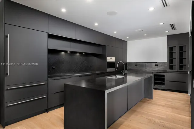 a kitchen with stainless steel appliances granite countertop a sink and a refrigerator