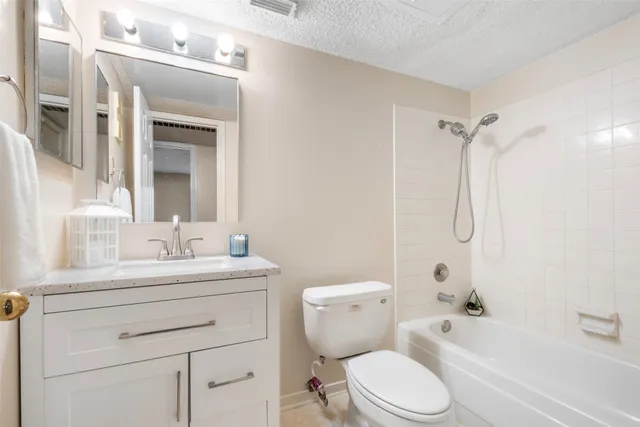 a bathroom with a toilet sink vanity tub and shower