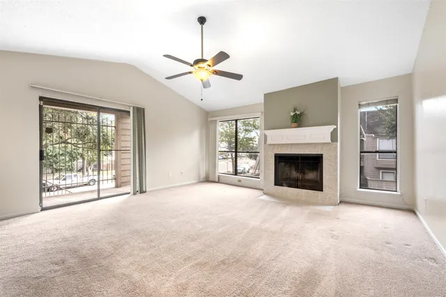 a view of an empty room with a fireplace and a window