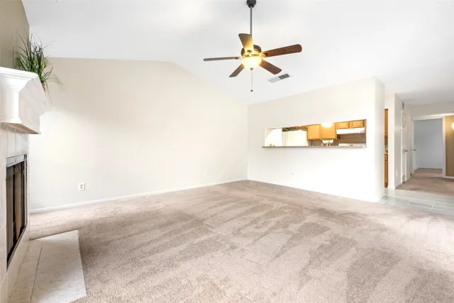 a view of a room with a ceiling fan and a window