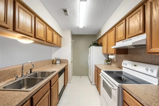 a kitchen with stainless steel appliances granite countertop a sink and a stove