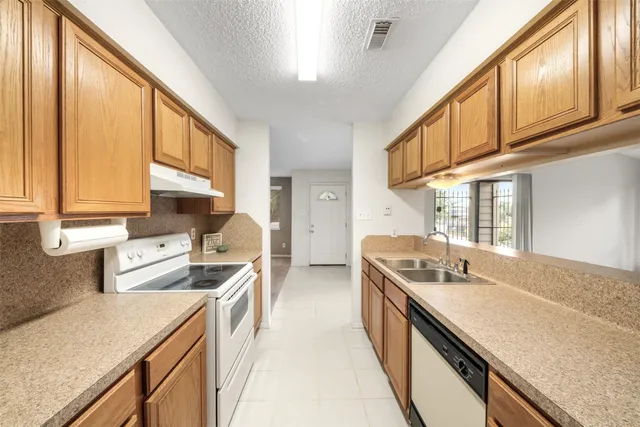 a kitchen with stainless steel appliances granite countertop a sink and a stove