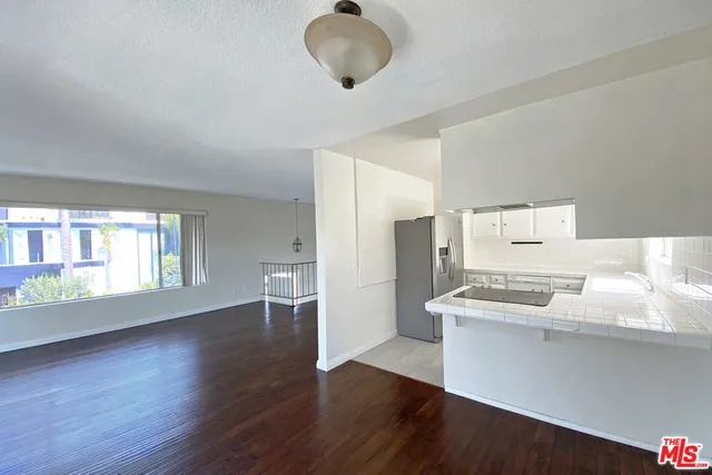 a living room with stainless steel appliances furniture and a window