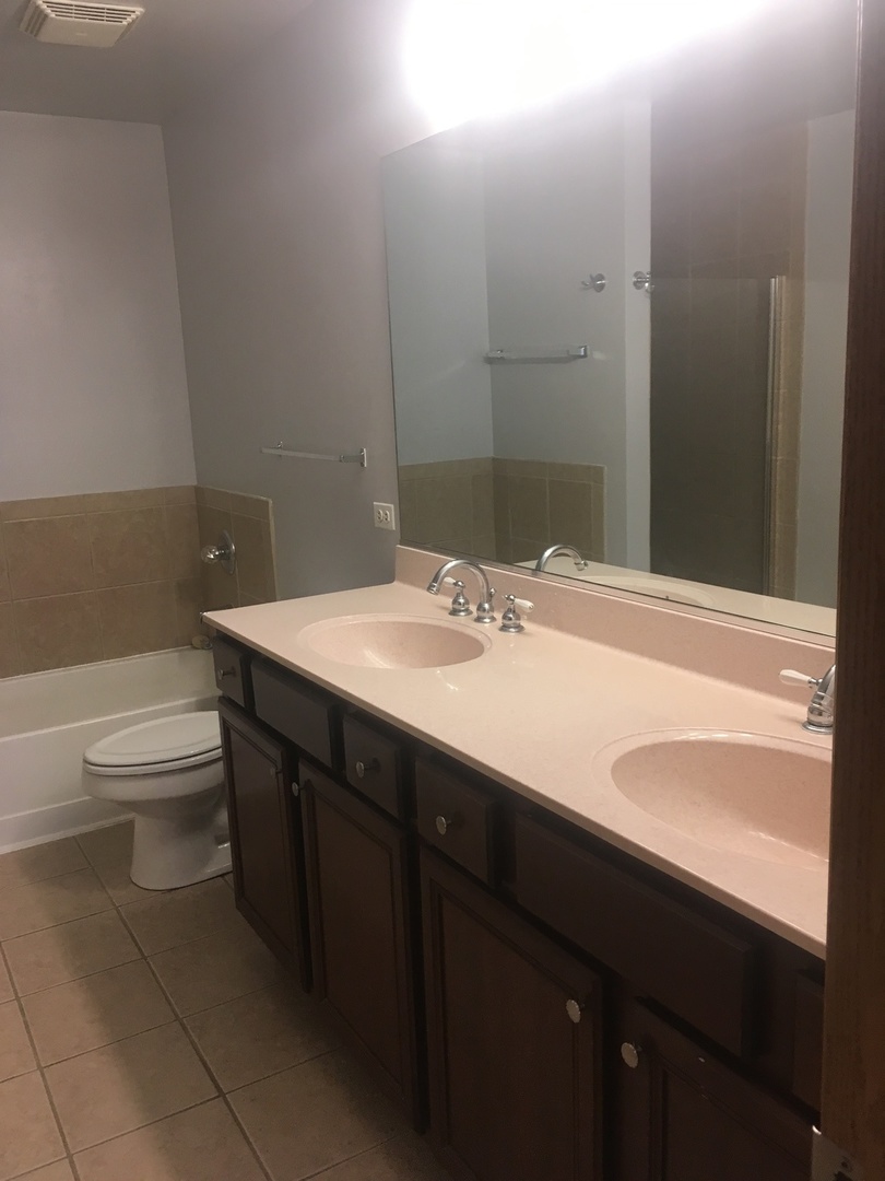 515 Main Street, Unit 608 Evanston, IL 60202 - Photo 19 of 21 a bathroom with a sink a toilet and a mirror