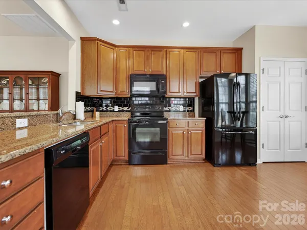 a kitchen with stainless steel appliances granite countertop a refrigerator stove top oven a sink and dishwasher