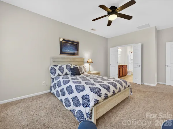 a bedroom with a bed and painting on the wall