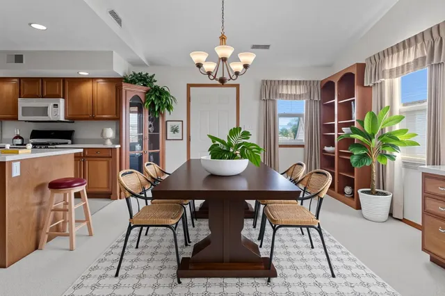 a dining room filled chandelier and wooden floor