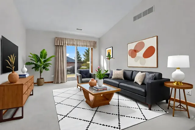 a living room with furniture potted plant and a large window