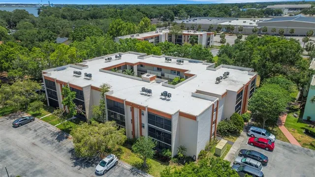an aerial view of a house with balcony and trees al around
