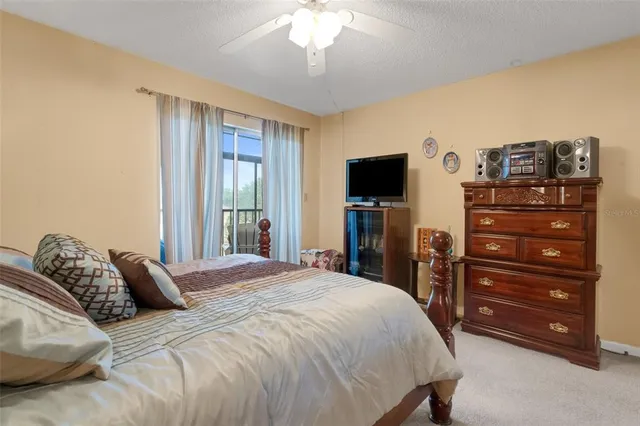 a bedroom with a bed and a flat tv screen on dresser