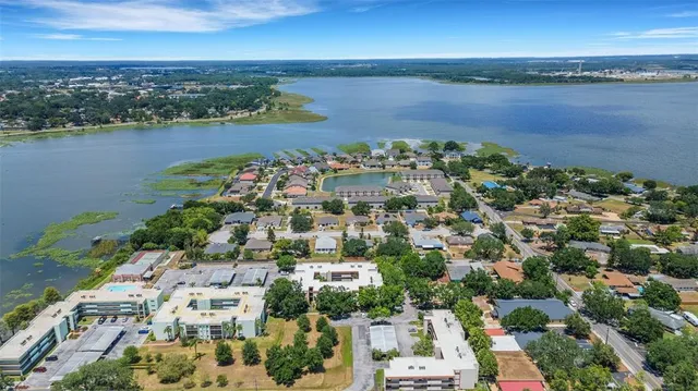 an aerial view of ocean and residential houses with outdoor space