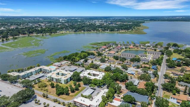 an aerial view of a city with lots of residential buildings ocean and mountain view in back