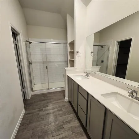 a bathroom with a double vanity sink mirror and shower